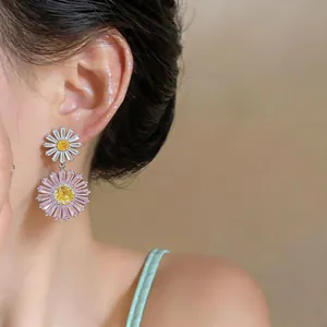 Close-up of double layered daisy flower earrings with pink and white zircon stones.