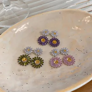Detail view of colorful zircon daisy drop earrings in purple, green, and pink colors