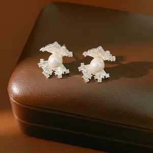 Elegant silver fan-shaped zircon stud earrings with central pearl on brown leather box