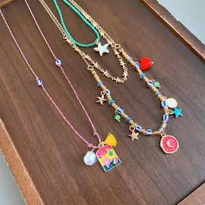 Detailed view of a retro 4-piece necklace set with starfish, heart and pearl charms.
