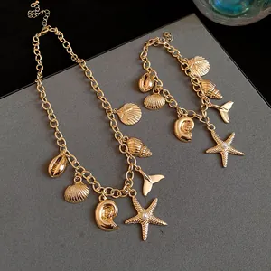 Detail view of a gold necklace and bracelet set with starfish shell charms and pearls