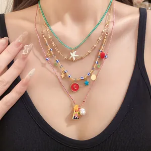 Close-up detail of 4-piece layered necklace set featuring starfish and pearl charms.