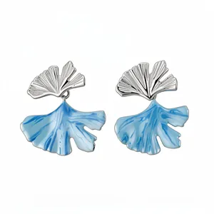 Elegant ginkgo leaf stud earrings with blue enamel drip design and silver finish.