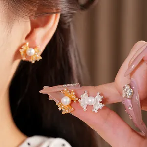 Detail view of elegant fan-shaped pearl stud earrings in gold and silver