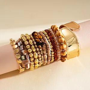 Vue détaillée d'un ensemble de 12 bracelets bohèmes avec joncs dorés et perles en bois