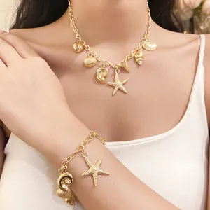 Gold necklace and bracelet set with starfish and seashell charms worn by a model