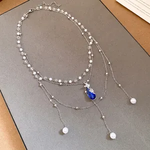 Elegant double-layer pearl necklace featuring a blue crystal water drop and butterfly pendant.