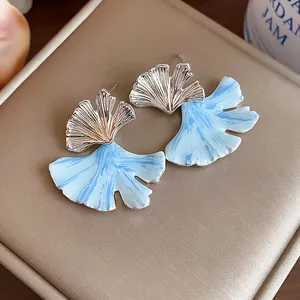 Exquisite detail of ginkgo leaf stud earrings featuring a unique light blue oil-drip texture