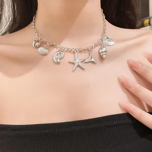 Detailed view of silver sea-themed charm necklace with pearl starfish and shells