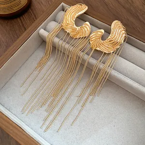 Elegant gold C-shaped tassel earrings featuring long ball chain drops in a jewelry box display