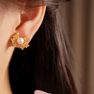 Elegant fan-shaped pearl stud earrings with zircon detail shown worn on a model's ear