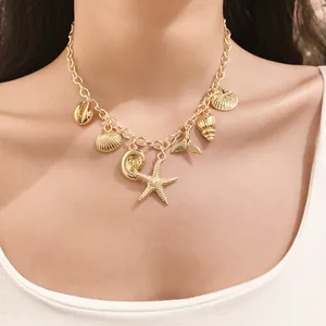 Close-up of a gold sea-themed necklace featuring starfish and shell charms on a model
