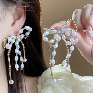Close-up detail of elegant bow-shaped earrings featuring pearls and brilliant zircon stones.