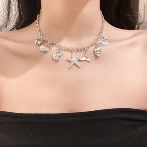 Detailed view of a silver-tone necklace featuring sea shell and starfish charms on a model