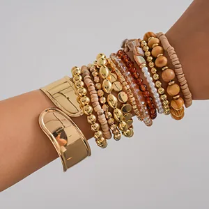Vue détaillée d'un ensemble de douze bracelets avec joncs dorés et perles en bois