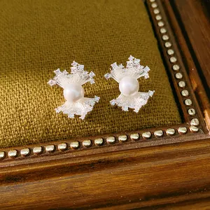 Close-up of fan-shaped cubic zirconia pearl earrings on vintage textured background