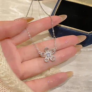 Détail d'un pendentif en forme de fleur évidée en argent avec une pierre de zircon