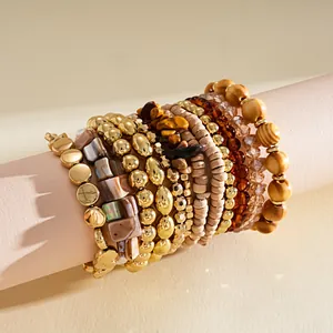 Vue détaillée d'un ensemble de bracelets bohèmes avec perles dorées, bois et nacre.