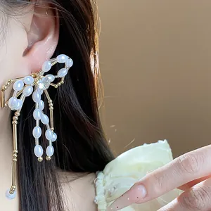Close-up of an elegant bow-shaped earring featuring pearls and a sparkling zircon stone