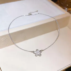 Vue détaillée d'un collier en argent avec pendentif fleur évidé et zircon au centre.