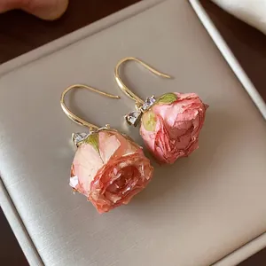 Elegant handmade preserved rose bud earrings with zircon accents on golden hooks
