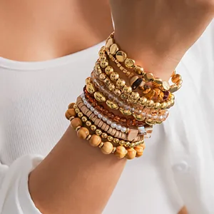 Vue détaillée d'un ensemble de 12 bracelets superposés avec perles métal et bois