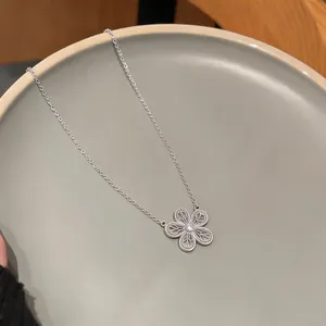 Détail d'un collier fleur en argent avec un design de pétales ajourés délicat