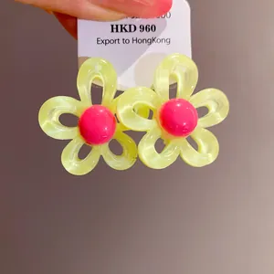 Close-up detail of sweet colorful resin flower stud earrings presented on a display card