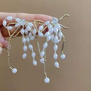 Close-up detail of elegant bow-shaped pearl earrings with sparkling zircon embellishments