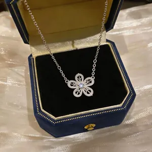 Gros plan d'un élégant collier fleur évidée en argent avec zircon dans son écrin