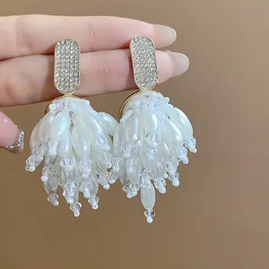 Macro view of elegant tassel earrings featuring white pearls and sparkling crystal beads