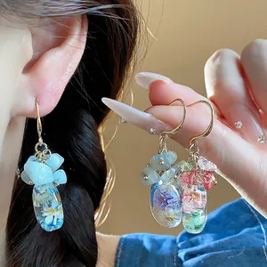 Exquisite handmade resin dried flower earrings with natural stone beads on Asian model