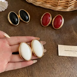 Vintage oversized oval resin stud earrings with gold frame in black, red, and white