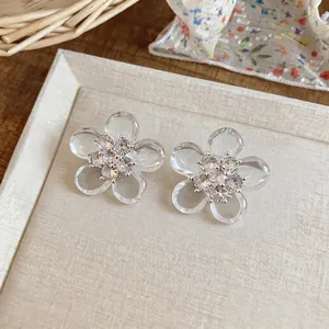 Primo piano di eleganti orecchini a fiore trasparente con zirconi scintillanti.