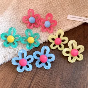 Detailed view of four pairs of colorful resin flower stud earrings for vacation