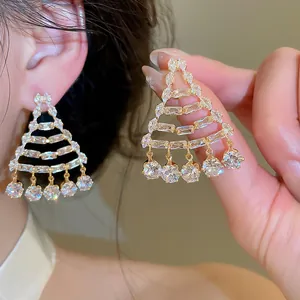Close-up of luxury zircon geometric tassel earrings with gold finish and wearing effect.