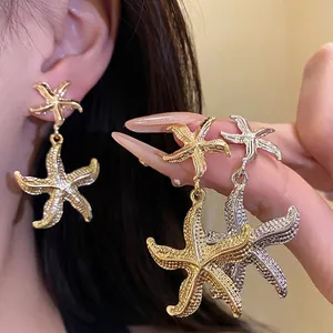 Elegant gold and silver metal starfish drop earrings with realistic sea life texture