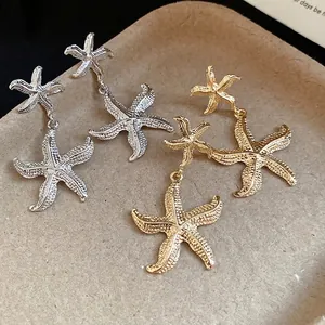 Elegant textured metal starfish dangle earrings set in brilliant gold and silver finishes