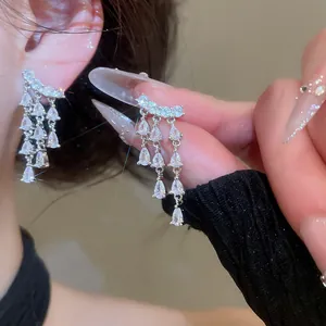 Detail shot of silver needle tassel earrings with sparkling teardrop zircons