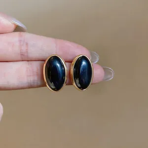 Detailed macro shot of vintage oval resin earrings with elegant gold bezel