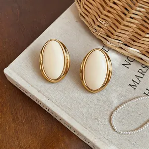 Close-up of vintage-style oval resin stud earrings featuring elegant gold-tone metal borders