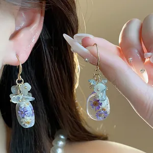 Exquisite resin earrings featuring real purple dried flowers and blue natural stones.