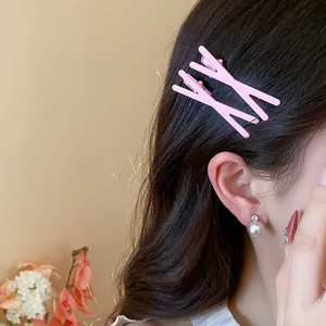 Close-up detail of two stylish pink minimalist duckbill hair clips worn on hair with pearl
