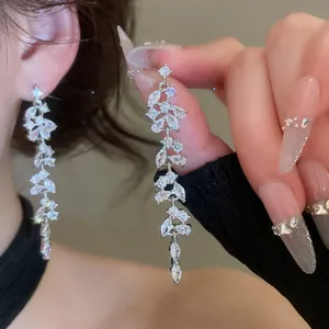 Close-up of silver needle zircon geometric tassel earrings with brilliant sparkle.