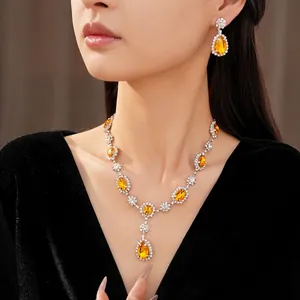 Elegant jewelry set with yellow teardrop stones and rhinestones worn by model.