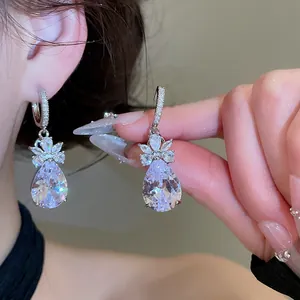Detail of pear-cut zircon drop earrings with floral marquise cluster in silver finish