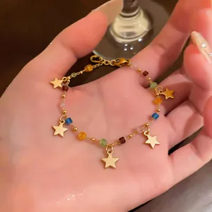 Primo piano di un bracciale in acciaio inossidabile con stelle dorate e perline colorate