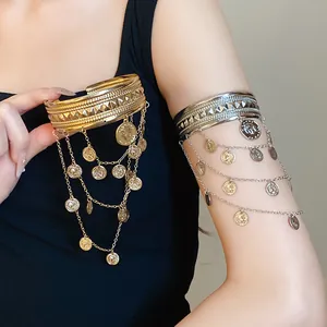 Detailansicht eleganter Armreifen in Gold und Silber mit verzierten Porträt-Münzquasten.
