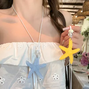 Close-up detail of vibrant dopamine color starfish pendant necklace worn by a model