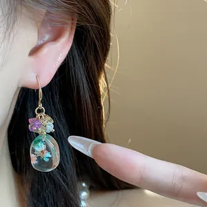 Exquisite close-up of ethnic resin flower drop earring with natural stones on ear
